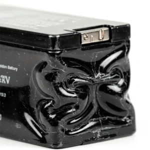 Крупный план сильно вздутого черного аккумулятора с мятым корпусом